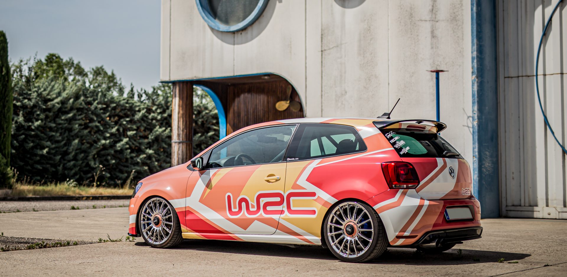 static VW polo Wrc mit Digitaldruck Folierung in lachs mit weiß pinken Akzenten und einer Scheinwerferfolierung. Autofolierung und Grafikdesign in Salzburg by Mozzart