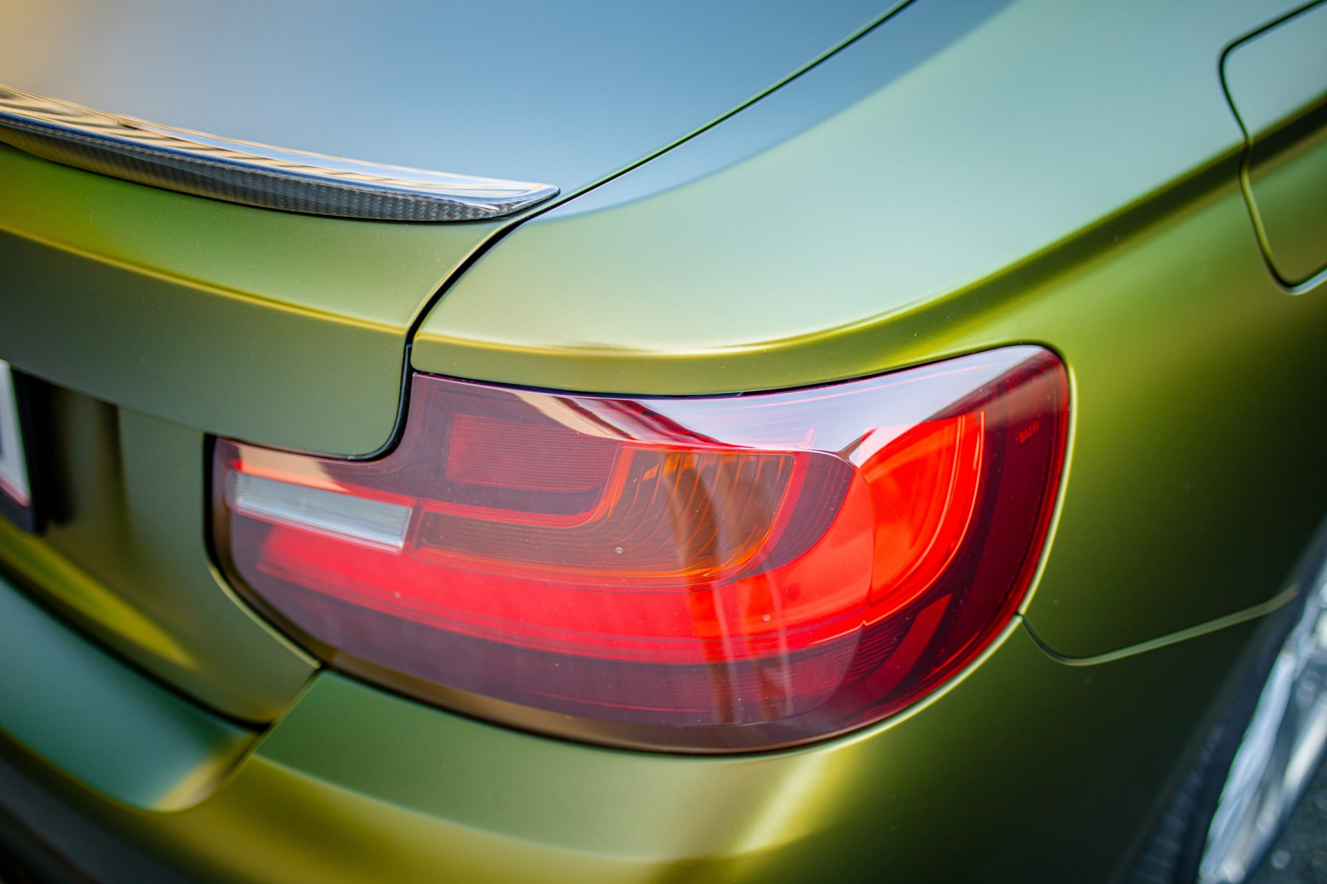 Eine Detailbild von einem zweier BMW, voll foliert in einer gold-grün schimmernden speziellen flipflop Folie mit einem seidenmattem Finish. Tuning Avery Auto Folie in Salzburg