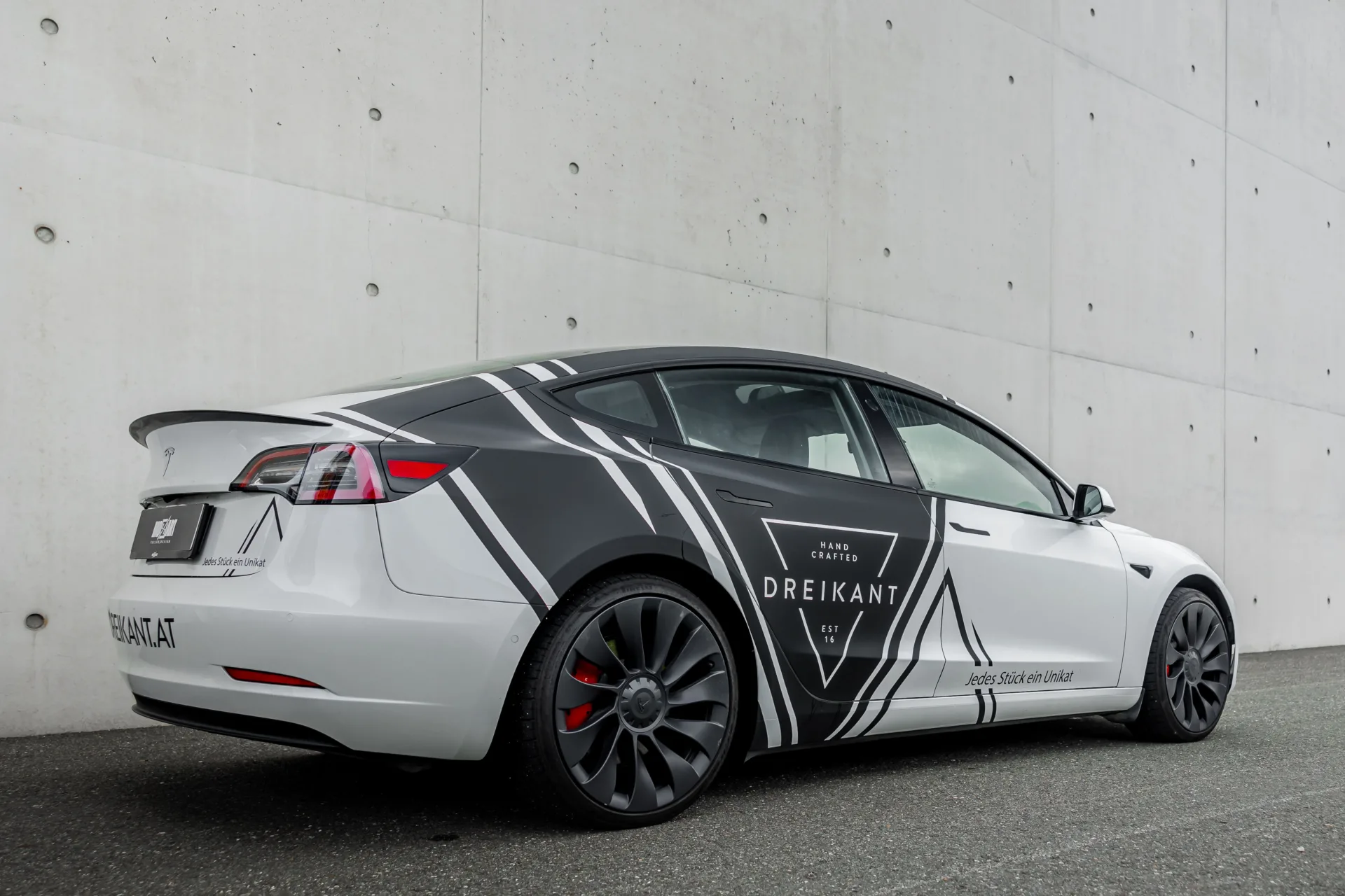 weißer Tesla Model 3 mit Dreikant Design Firmenbeschriftung