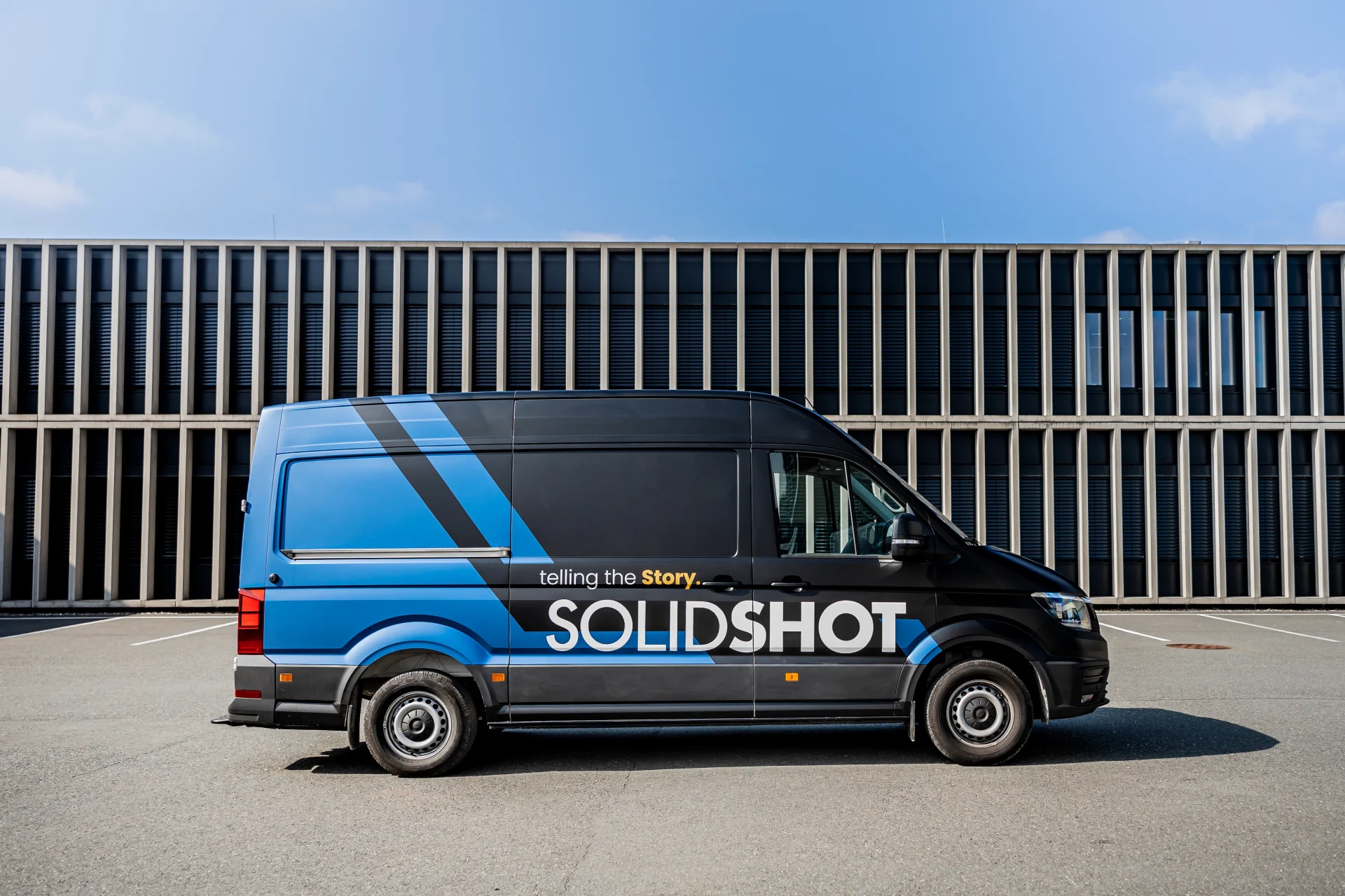 Satin matt schwarze Vollfolierung und blau matte Solidshot Fahrzeugbeschriftung auf einem VW Crafter