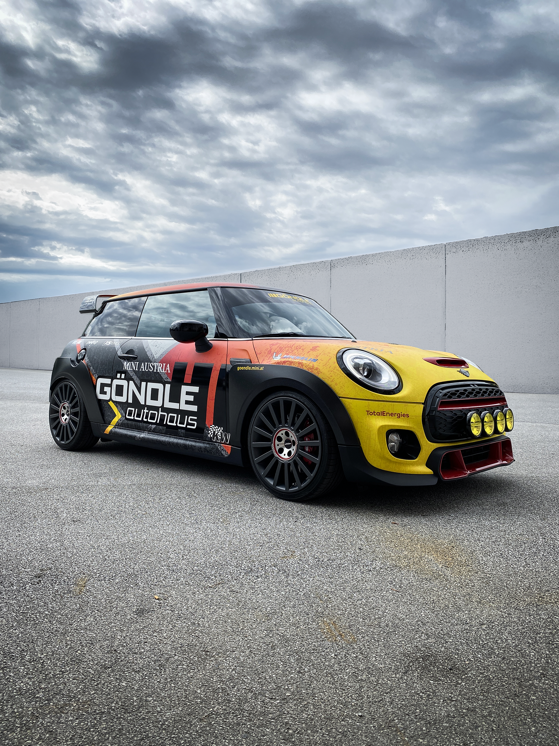 John Cooper Works von Autohaus Göndle mit einer Verlauf Folierung in gelb rot mit Firmenbeschriftung in Motorsportoptik